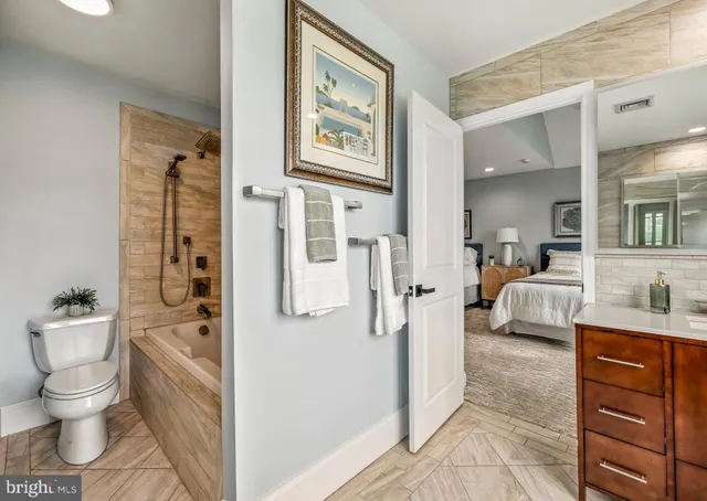 a large bathroom with a tub sink and mirror