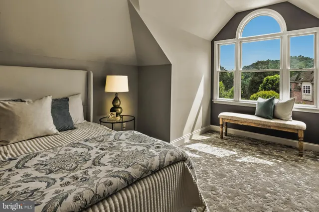 a spacious bedroom with a bed and ceiling fan