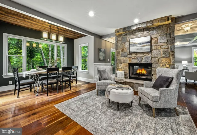 a living room with furniture a fireplace a flat screen tv and a large window