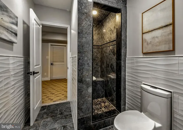 a view of a white house with a small yard and large trees