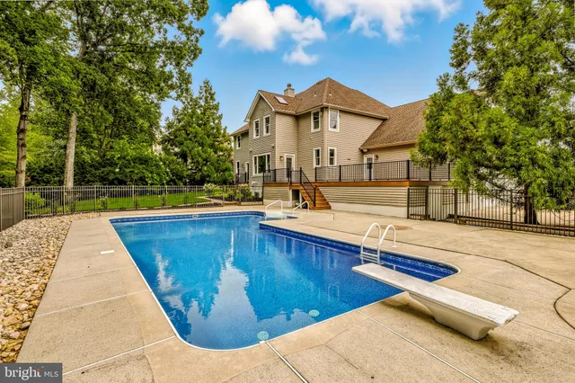 a view of a white house with a big yard and large trees
