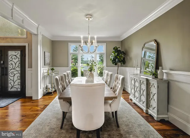 a dining room with furniture a chandelier and wooden floor