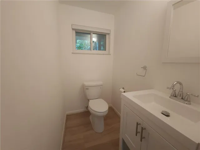 a bathroom with a toilet a sink a vanity and mirror