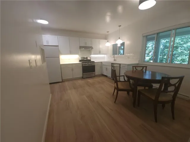 a kitchen with stainless steel appliances granite countertop a white cabinets and wooden floor