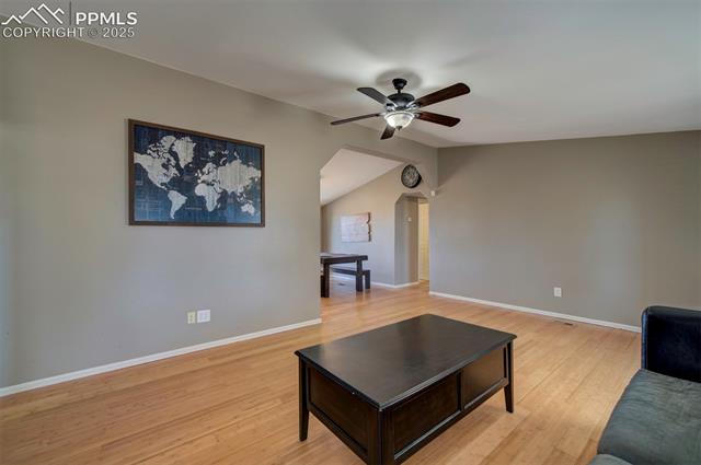 5860 Curtis Road Peyton, CO 80831 - Photo 6 of 28 Living room with baseboards, a ceiling fan, light wood-style floors, and arched walkways