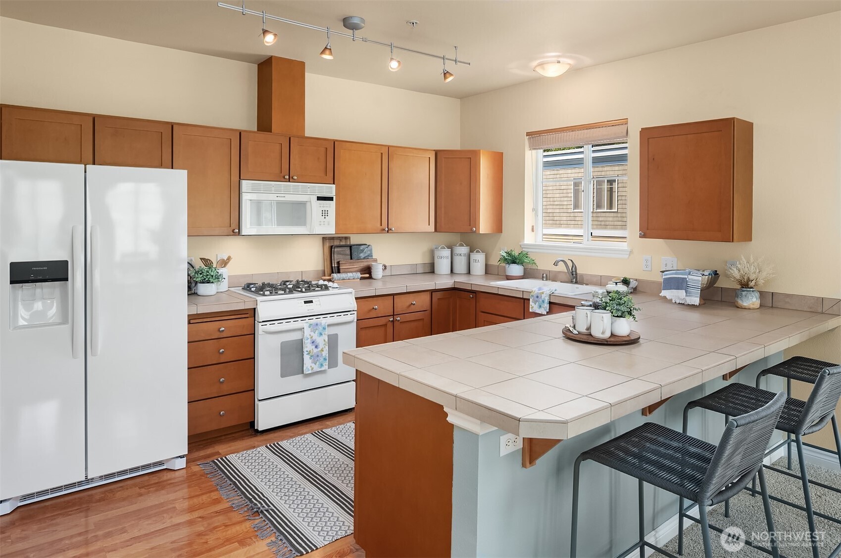 17432 Bothell Way Northeast, Unit B305 Bothell, WA 98011 - Photo 20 of 39 a kitchen with a sink a stove a refrigerator and white cabinets