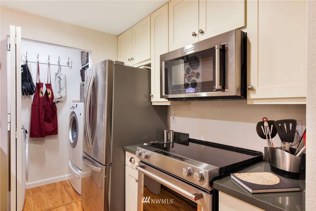2244 13th Avenue West, Unit 115 Seattle, WA 98119 - Photo 11 of 19 a kitchen with stainless steel appliances granite countertop a refrigerator and a stove top oven