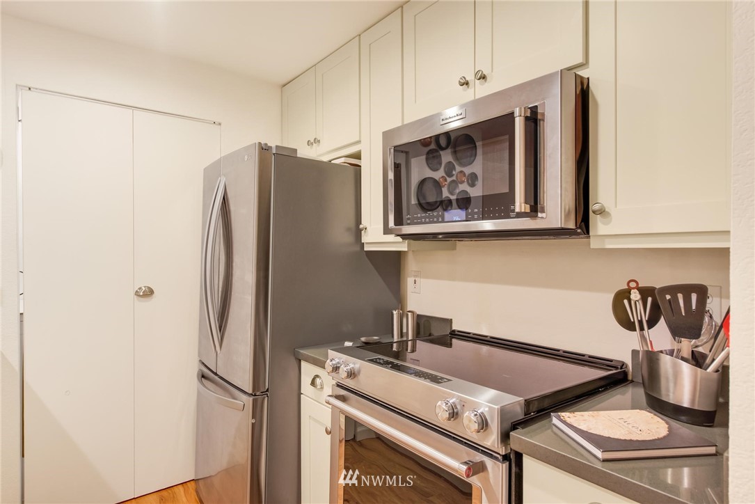 2244 13th Avenue West, Unit 115 Seattle, WA 98119 - Photo 9 of 19 a kitchen with stainless steel appliances granite countertop a refrigerator and a stove top oven