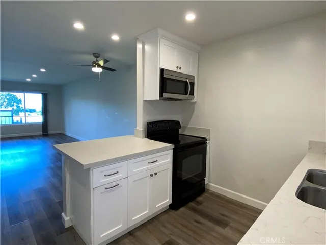 a kitchen with a sink a stove and cabinets