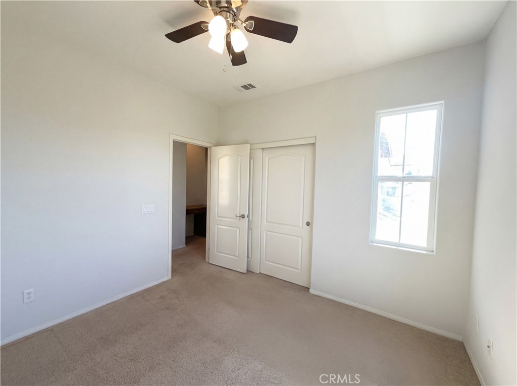 28745 Edenton Way Temecula, CA 92591 - Photo 18 of 23 an empty room with chandelier fan and windows