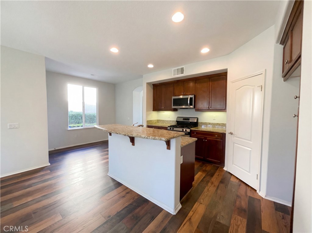 28745 Edenton Way Temecula, CA 92591 - Photo 8 of 23 a kitchen with kitchen island wooden floors appliances and cabinets