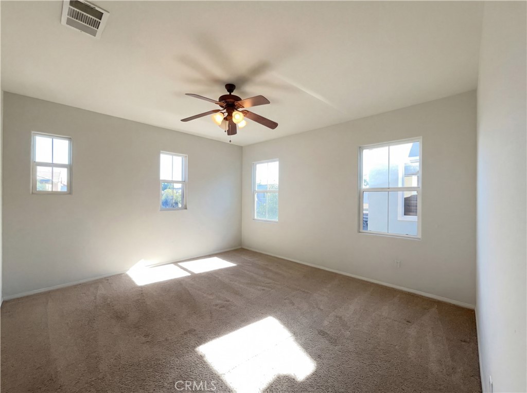 28745 Edenton Way Temecula, CA 92591 - Photo 10 of 23 an empty room with windows and chandelier fan