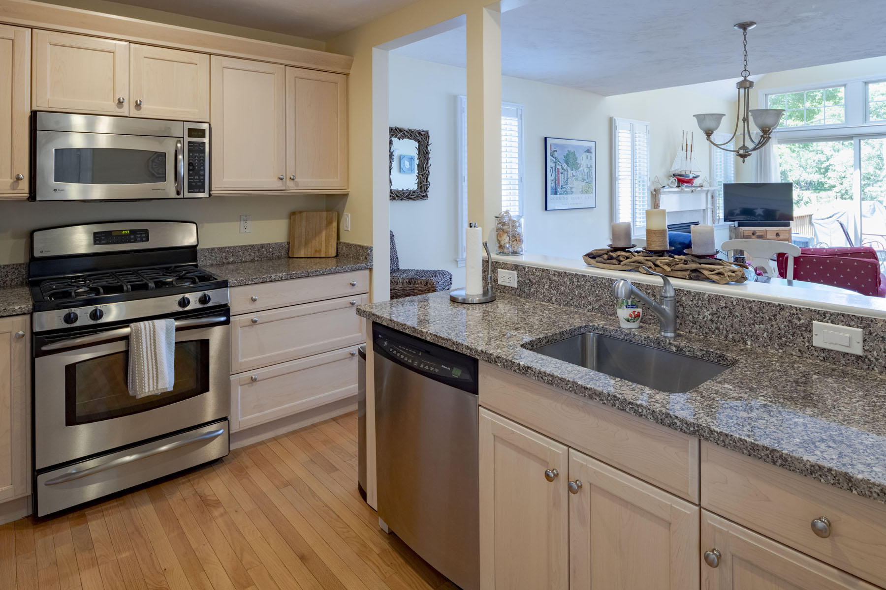 19 NW Landing Mashpee, MA 02649 - Photo 5 of 33 a kitchen with granite countertop a sink dishwasher a stove and a microwave oven with cabinets