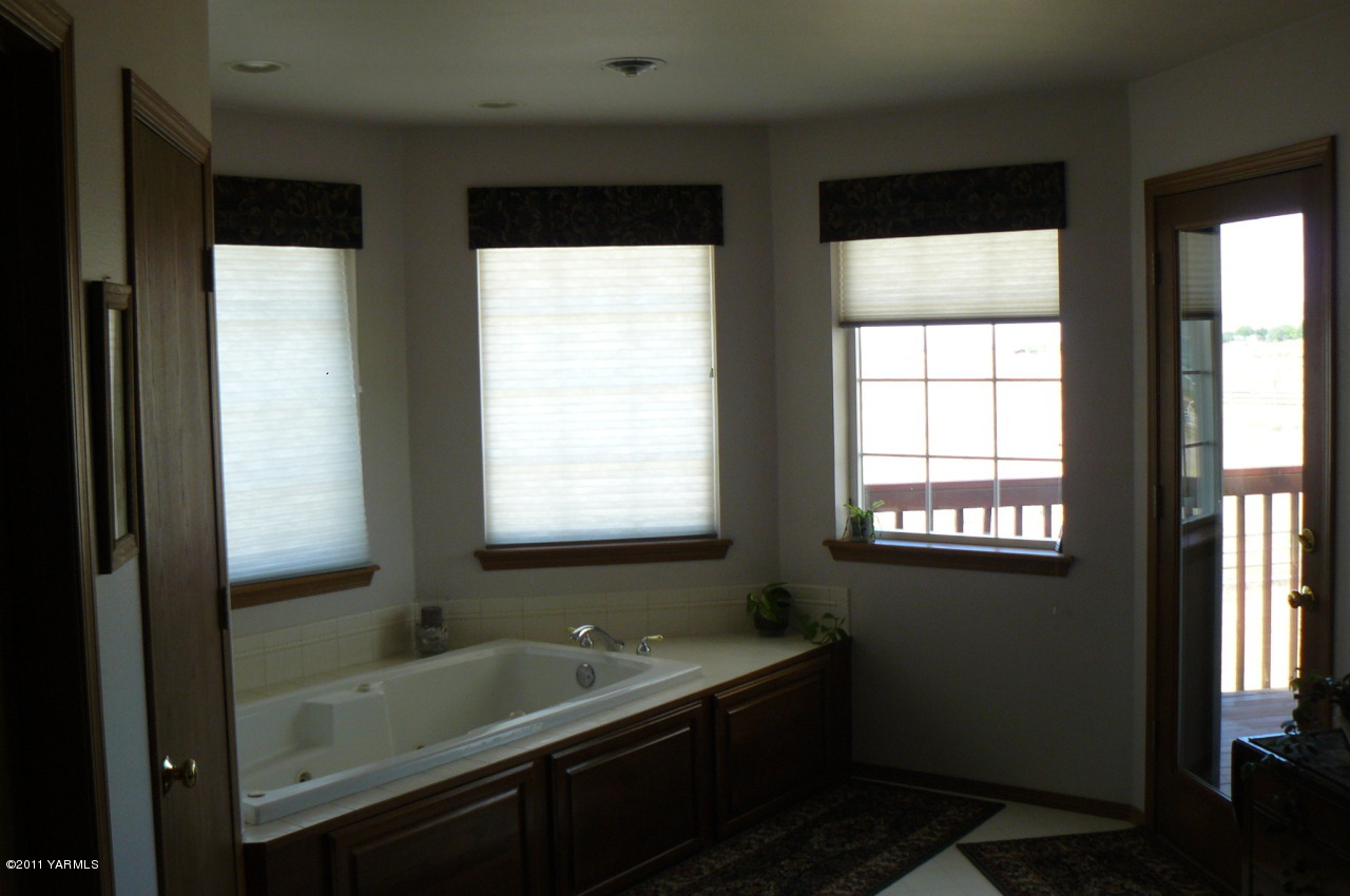 12074 Mieras Road Moxee, WA 98936 - Photo 19 of 22 a bathroom with a double vanity sink and a bathtub
