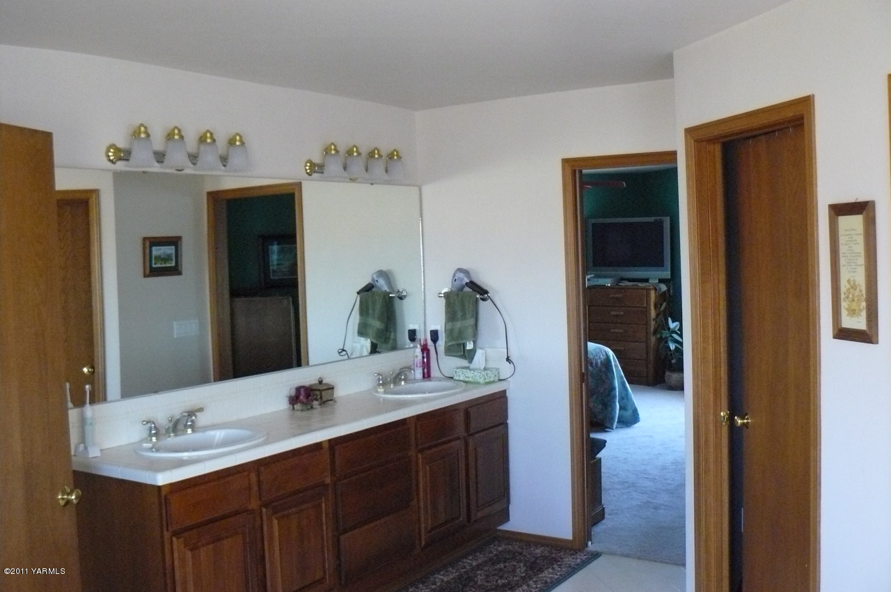 12074 Mieras Road Moxee, WA 98936 - Photo 20 of 22 a en suite bathroom with a double vanity sink and a mirror