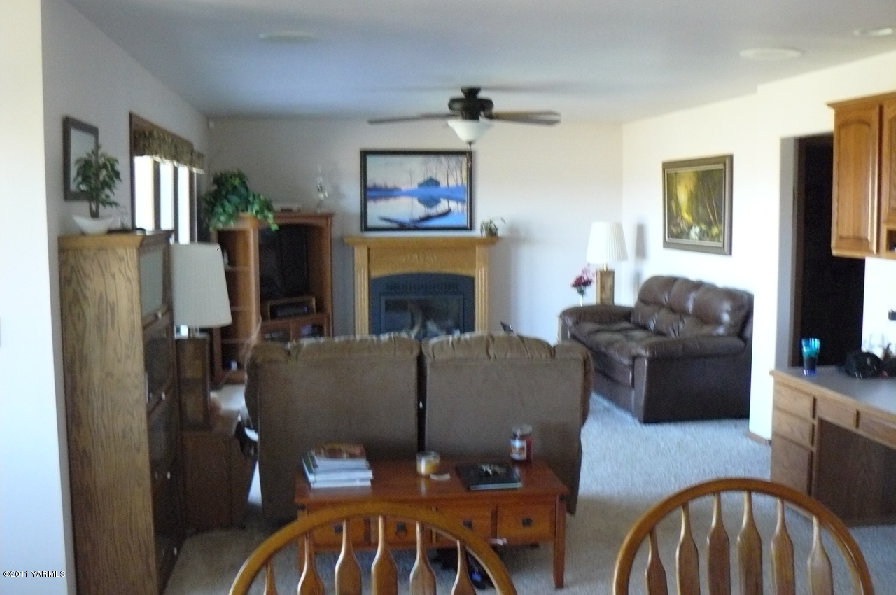 12074 Mieras Road Moxee, WA 98936 - Photo 3 of 22 a living room with furniture a flat screen tv and a fireplace