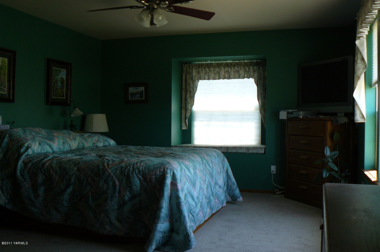 12074 Mieras Road Moxee, WA 98936 - Photo 21 of 22 a bed sitting in a bedroom next to a window