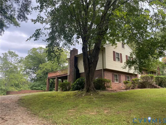 a front view of a house with a garden and tree
