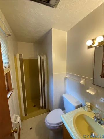 a bathroom with a sink a toilet a mirror and shower