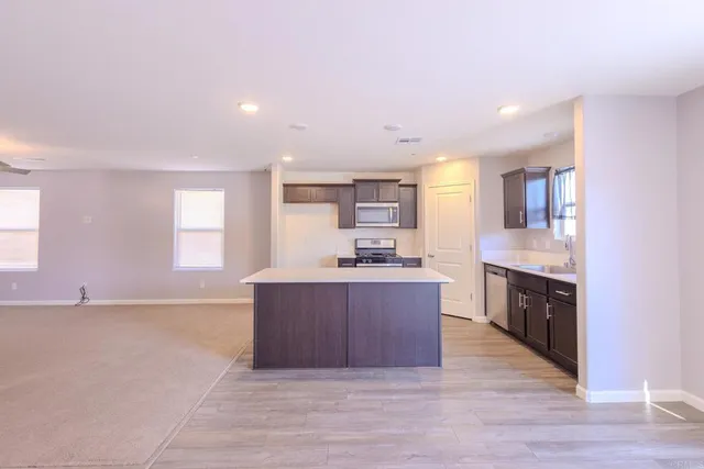 a large kitchen with stainless steel appliances granite countertop a large counter top a sink and a stove