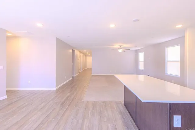 a view of a big room with wooden floor and windows