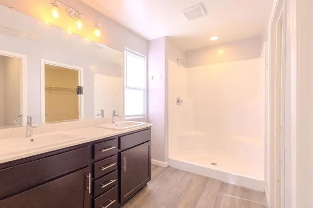 a bathroom with a sink a mirror and a shower