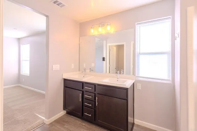 a bathroom with a double vanity sink and a mirror