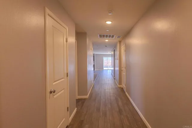 a view of a hallway with wooden floor