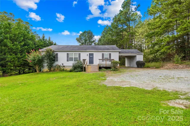 a front view of a house with a yard and trees