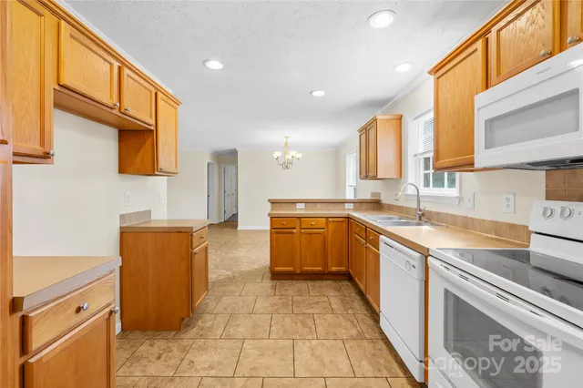 a large kitchen with stainless steel appliances granite countertop a sink and cabinets