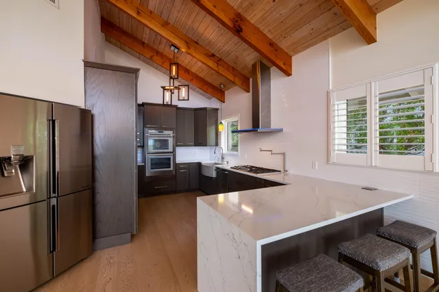 a kitchen with stainless steel appliances kitchen island granite countertop a stove a sink and a microwave