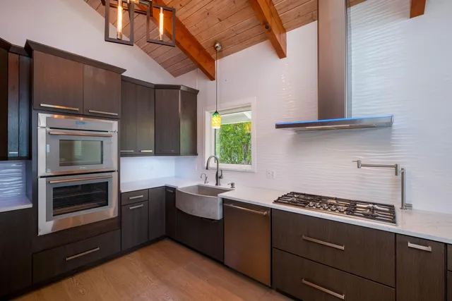 a kitchen with wooden floor and a stove top oven