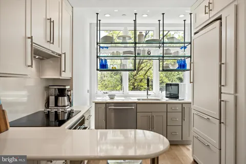 a kitchen with stainless steel appliances granite countertop a sink and a refrigerator