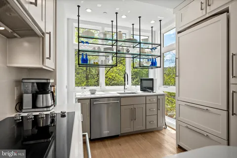 a kitchen with kitchen island a counter top space a sink stainless steel appliances and cabinets