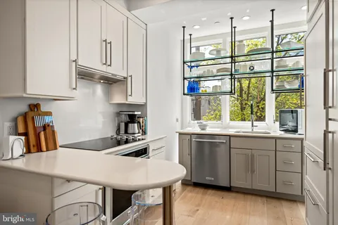 a kitchen with stainless steel appliances granite countertop a sink a stove and a refrigerator