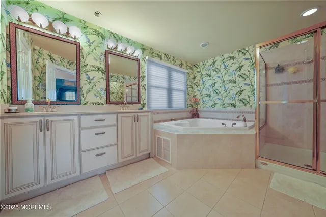 a bathroom with a tub a sink and mirror