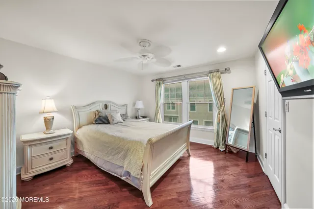 a bedroom with a large bed and a flat tv screen on a dresser