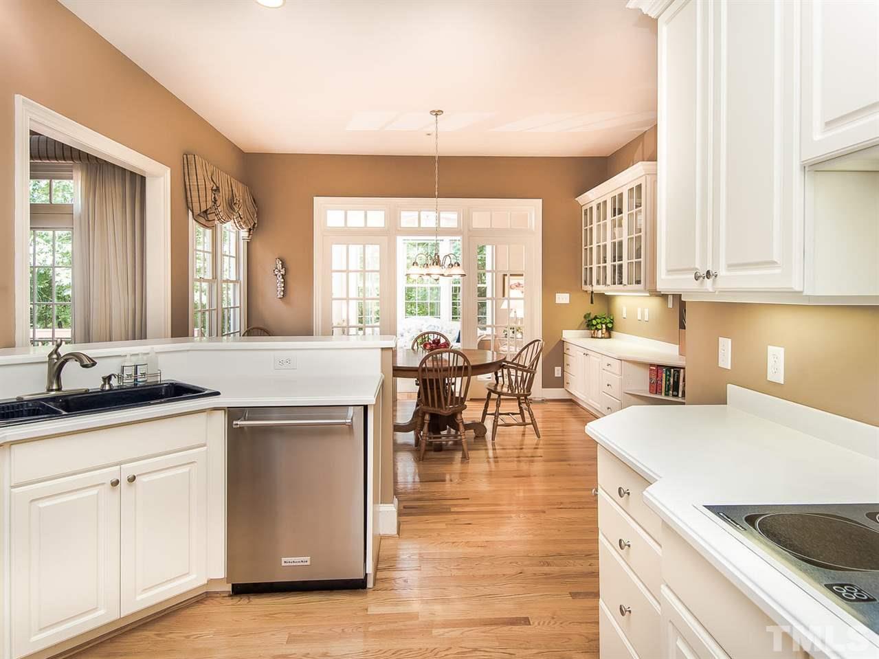 1108 Wagon Ridge Road Raleigh, NC 27614 - Photo 12 of 25 a open kitchen with granite countertop a sink and white cabinets with wooden floor