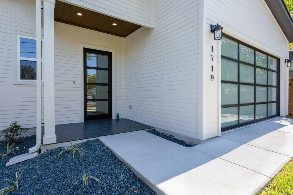 1719 Bunche Road Austin, TX 78721 - Photo 22 of 22 A striking modern facade with sleek siding and an inviting glass-paneled entry.