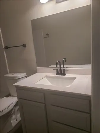 a bathroom with a sink a toilet and mirror