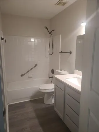 a bathroom with a granite countertop sink a toilet and shower