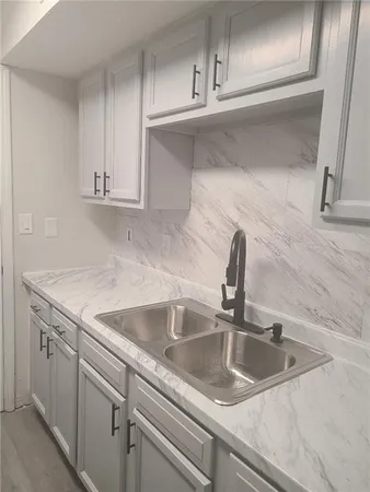 a close view of a sink and dishwasher with cabinets