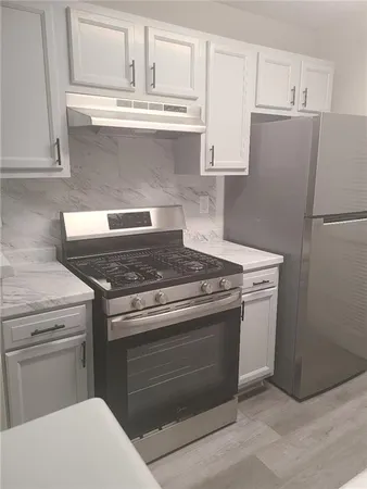a stove top oven sitting inside of a kitchen