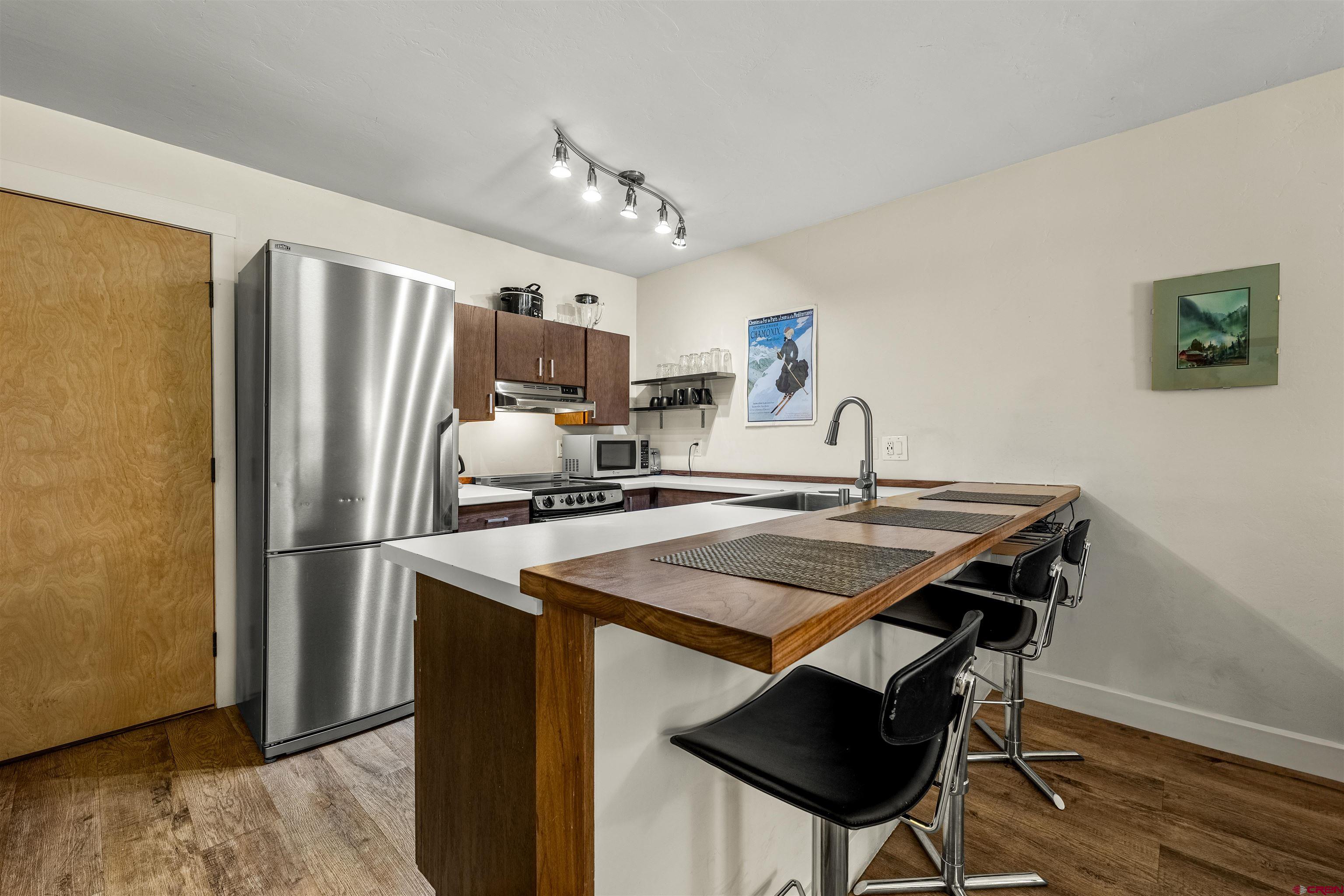 455 Sheol Street, Unit 209 Durango, CO 81301 - Photo 5 of 30 a kitchen with stainless steel appliances granite countertop a sink a stove a refrigerator and cabinets