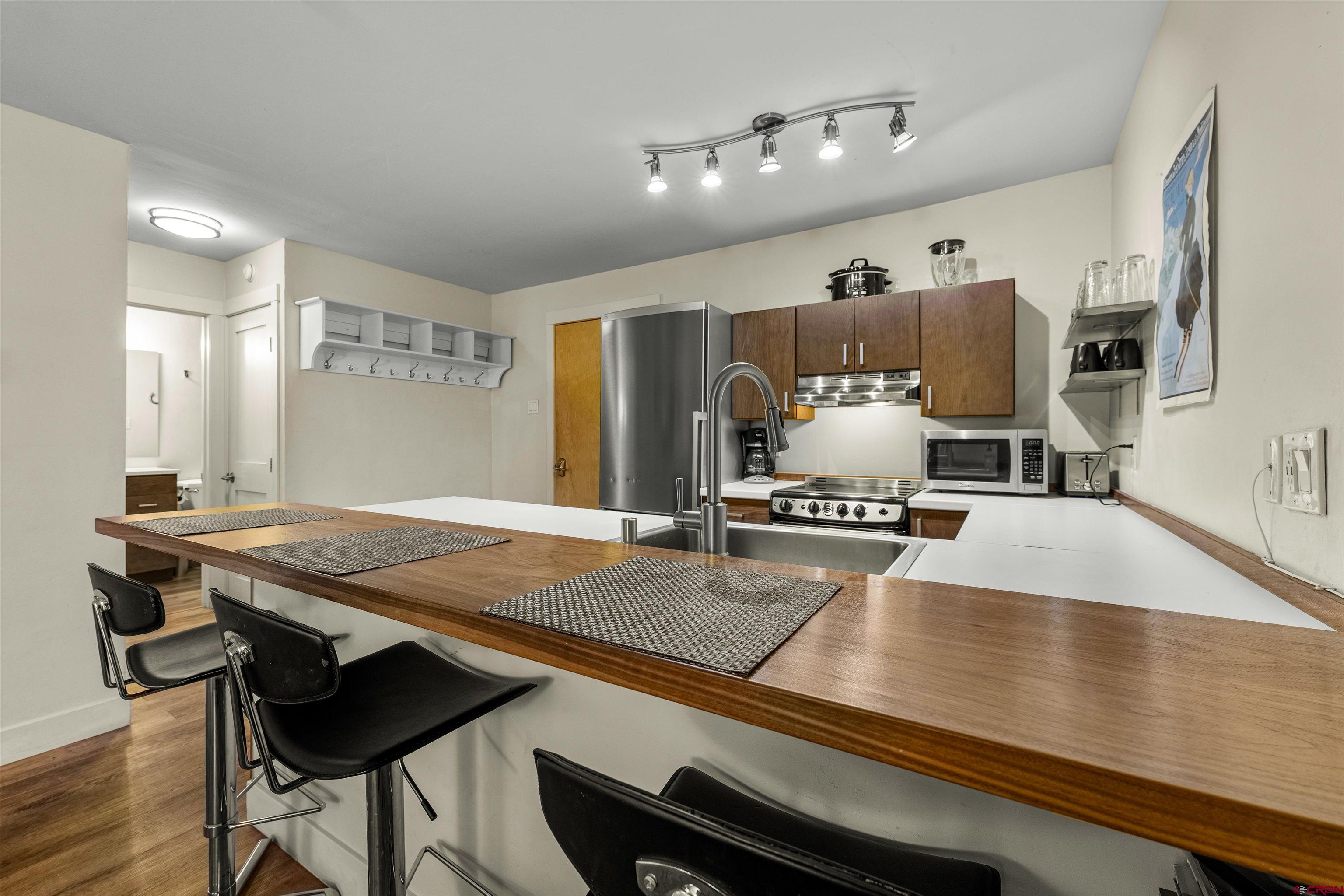 455 Sheol Street, Unit 209 Durango, CO 81301 - Photo 8 of 30 a view of a kitchen with kitchen island a counter and chairs