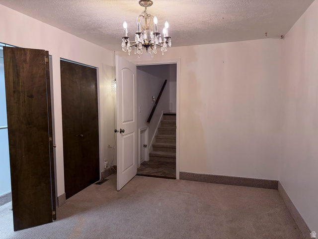 2855 South 1000 West Perry, UT 84302 - Photo 130 of 142 Unfurnished dining area with a textured ceiling, light carpet, and suspended lighting