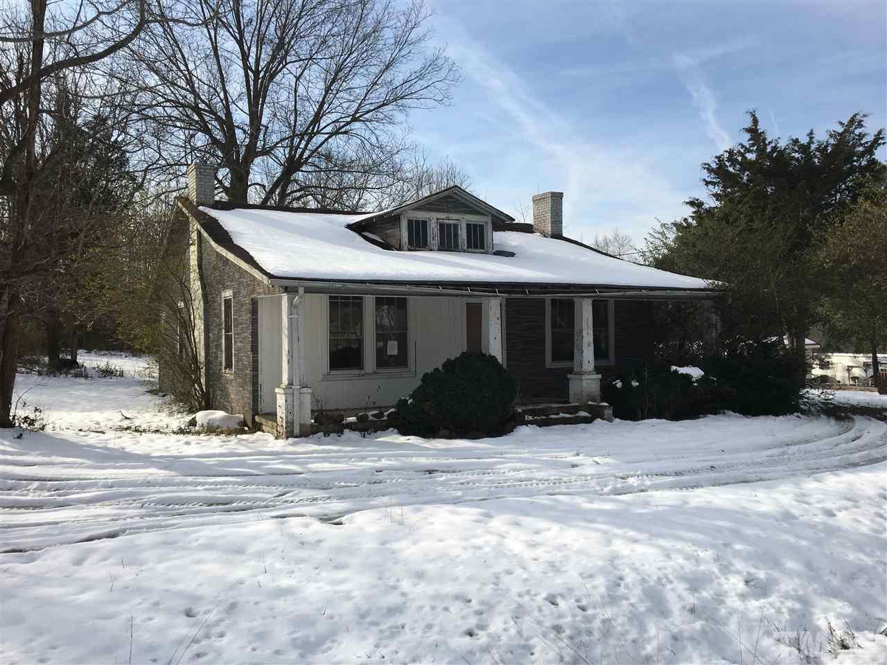 a front view of a house with a yard covered in snow