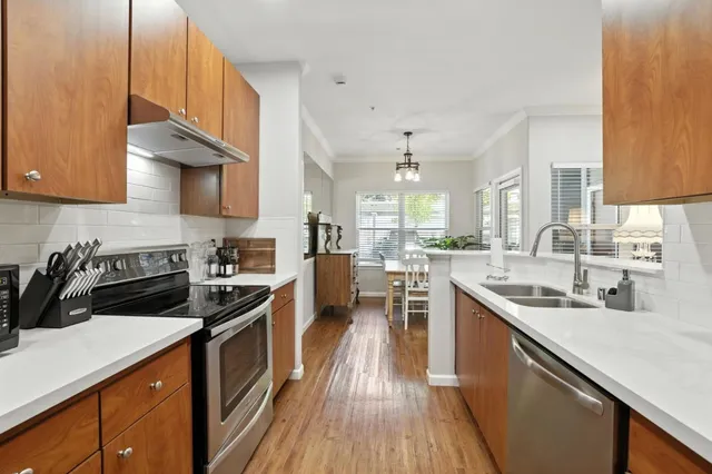 a kitchen with stainless steel appliances a sink stove and cabinets