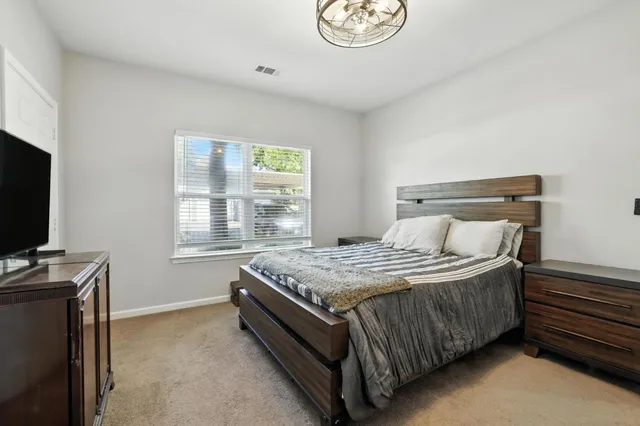 a bedroom with a bed and a flat tv screen on the dresser