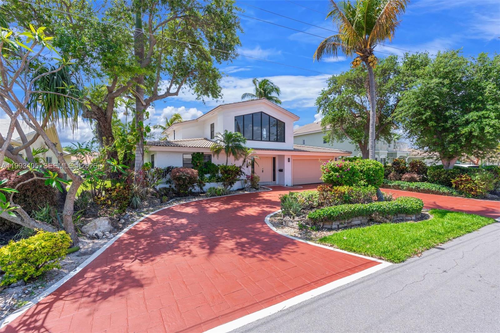 2858 Northeast 33rd Street Lighthouse Point, FL 33064 - Photo 8 of 24 a front view of a house with a yard and trees